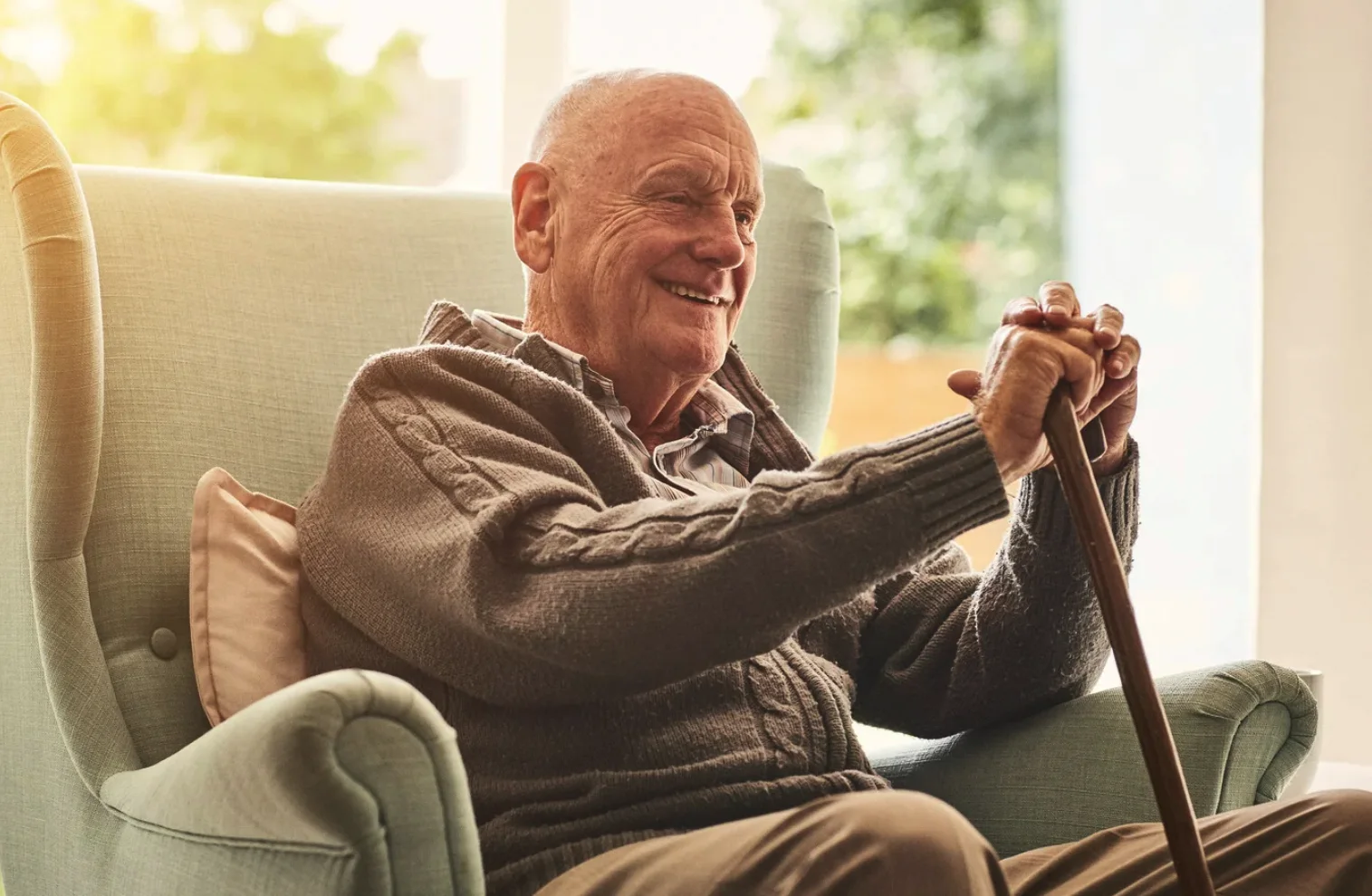 elderly man sitting with a cane