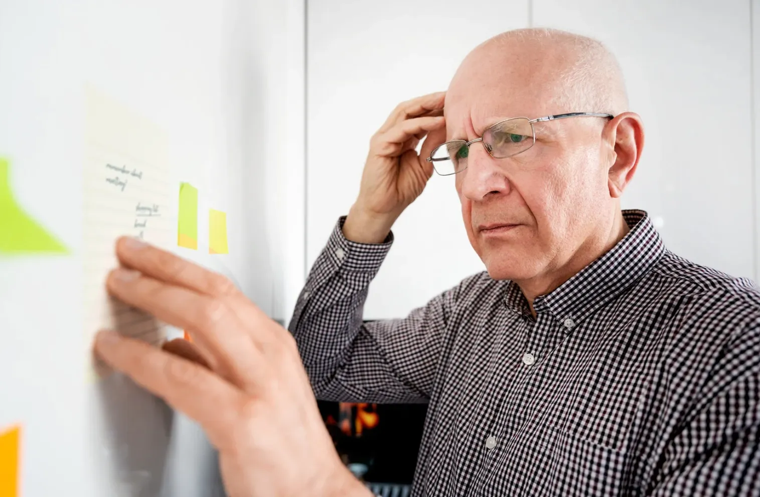 man forgetting and referring to note on the fridge