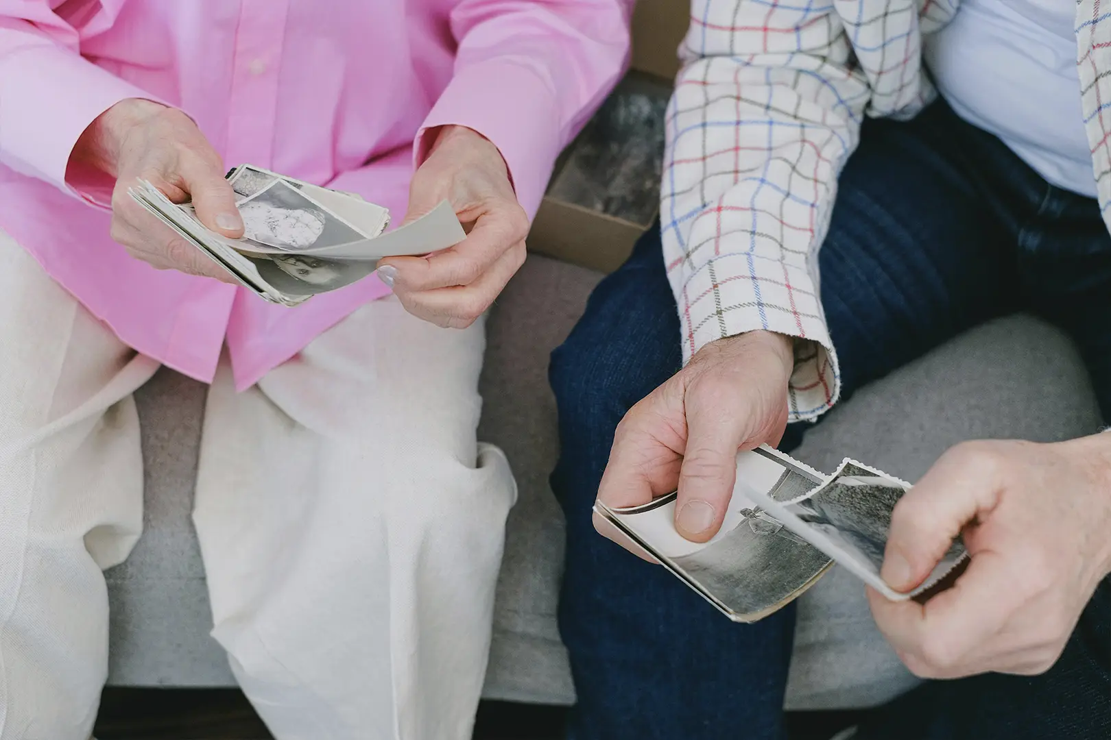 elderly mother looking at old photographs with family member