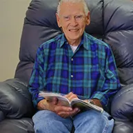 man sitting in a chair reading